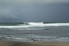 Beach with white waves on sundown